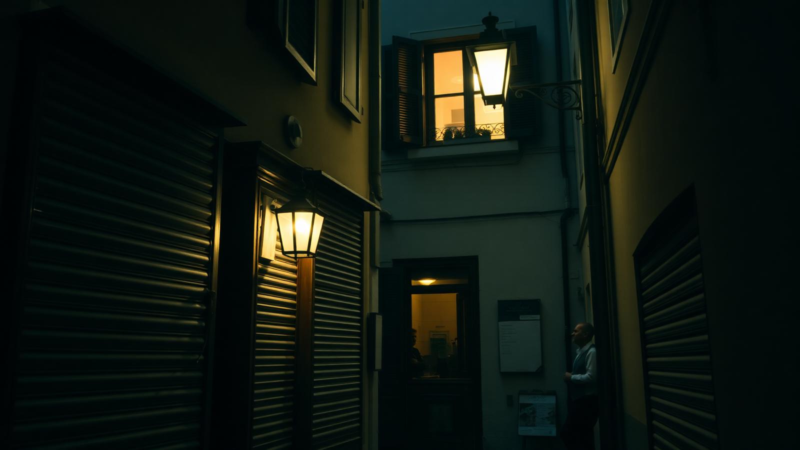 Strada italiana di notte con luce calda e chiusura serale di un pub